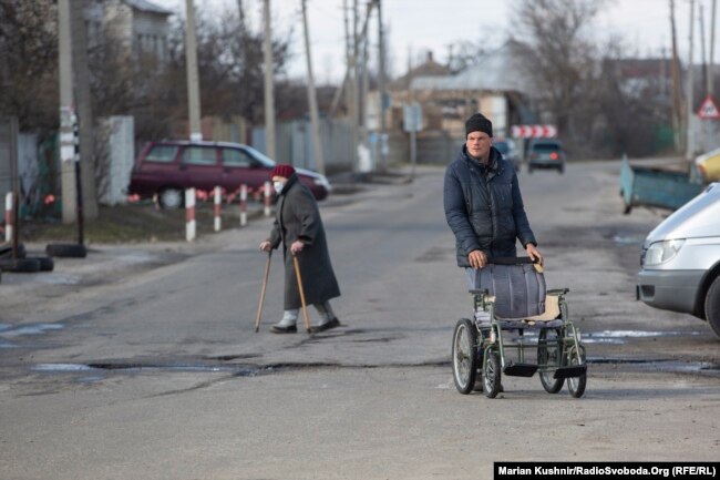 Në këtë rrugë pranë pikëkalimit në Stanytsya Luhanska ka dyqane që shesin gjëra ushqimore dhe barna, por edhe hapësira ku kryhen teste të shpejta për koronavirus.