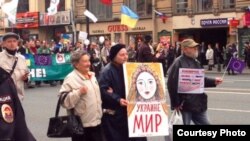 Російська активістка і художниця Олена Осипова несе антивоєнний плакат.