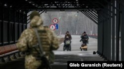 Qytetarët duke kaluar vijën e kontaktit ndërmjet separatistëve pro-rusë dhe trupave ukrainase në Stanytsia Luhanska më 23 shkurt, 2022.
