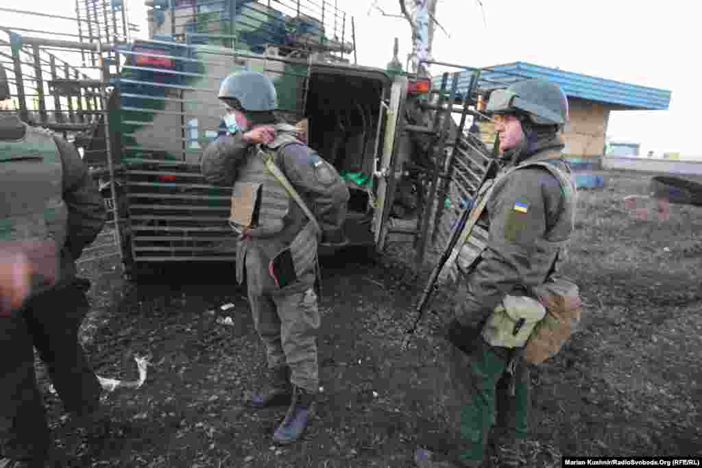 Ukrainian soldiers stand at the scene of the battle.