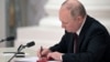 Рускиот претседател Владимир Путин потпишува документи, вклучително и декрет за признавање на две сепаратистички ентитети поддржани од Русија во источна Украина за време на церемонијата во Москва на 21 февруари.