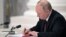 Рускиот претседател Владимир Путин потпишува документи, вклучително и декрет за признавање на две сепаратистички ентитети поддржани од Русија во источна Украина за време на церемонијата во Москва на 21 февруари.