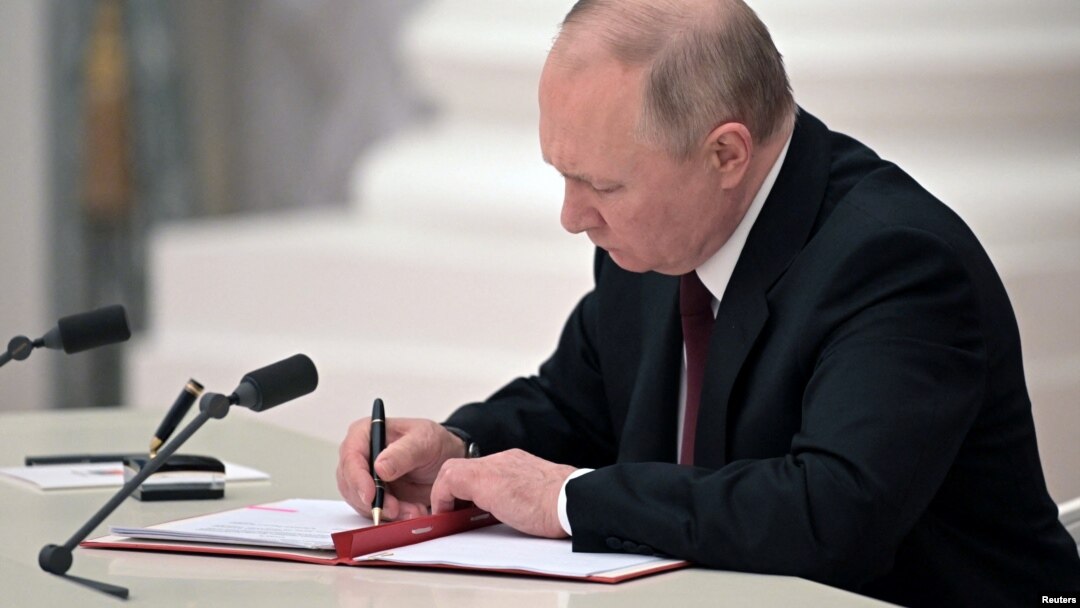 Russian President Vladimir Putin signs a decree recognizing two Russia-backed regions in eastern Ukraine as independent entities during a ceremony in Moscow on February 21.