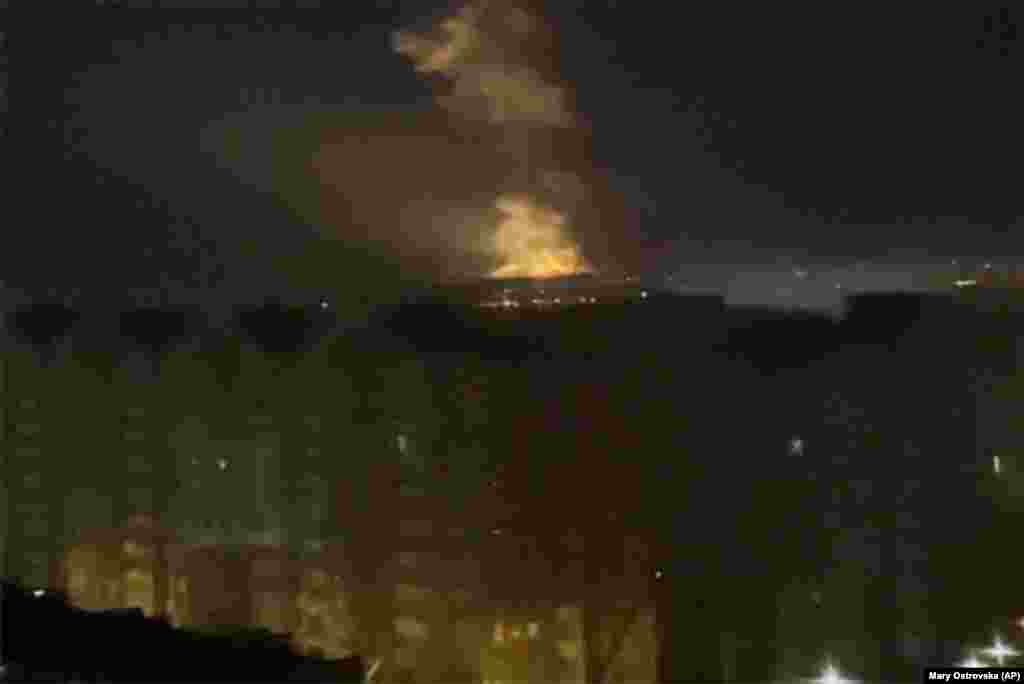Flames are seen from an area near the Dnieper River in Kyiv.