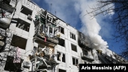 УКРАИНА -- Пожарникарите работат на пожар на зграда по бомбашките напади врз градот Чугуив во источна Украина на 24 февруари 2022 година. 