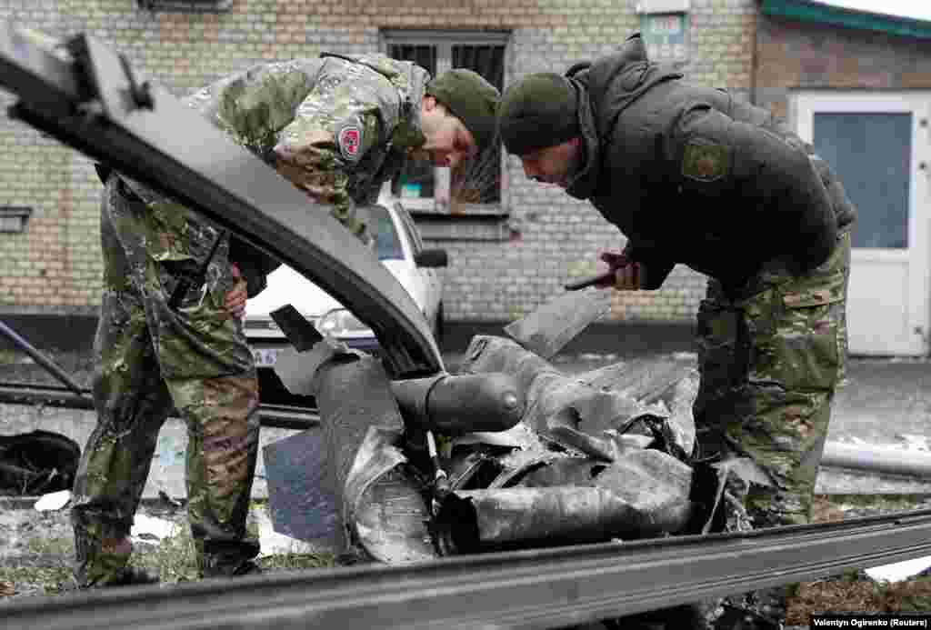 Polițiștii din Kiev inspectau, joi dimineață, rămășițele unei bombe care a căzut pe o stradă din Kiev. &nbsp;