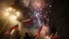 UKRAINE -- Pro-Russian activists react in a street as fireworks explode in the sky, after Russian President Vladimir Putin recognized two Russian-backed breakaway regions in eastern Ukraine as independent entities, in the separatist-controlled city of Donetsk, February 21, 2022.