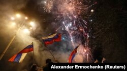 UKRAINE -- Pro-Russian activists react in a street as fireworks explode in the sky, after Russian President Vladimir Putin recognized two Russian-backed breakaway regions in eastern Ukraine as independent entities, in the separatist-controlled city of Donetsk, February 21, 2022.