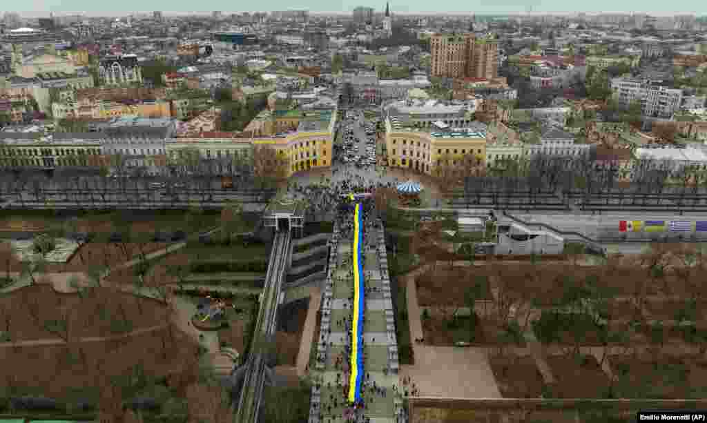 Demonstrators holding a huge Ukrainian flag march along a street in Odesa, Ukraine. Thousands marched through the streets of the city in a show of unity on February 20, marking the date on which, eight years ago, more than 100 people were killed during Ukraine&#39;s Maidan revolution.