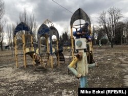Šestogodišnji Ženja igra se na starom školskom igralištu u centru grada Novoluhanska na liniji fronta u Ukrajini, 19. februara. Grad nije što je nekad bio, svi su se odselili, kaže njegov otac Sergej Krajnov.