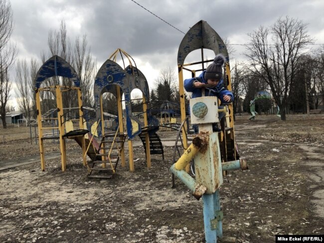 Zhenya, djali i Serhiy Krainov, duke lozur në një shesh lojërash.