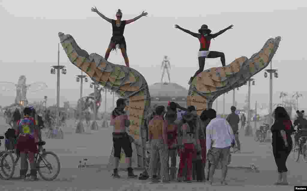 Gessica Preto Martini (left) and Amma Antwi-Agyei pose for a photo atop an art installation.