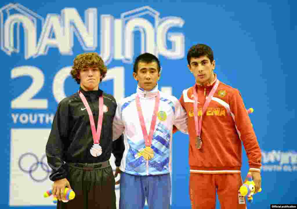 Казахстанский спортсмен Мухамбет Куатбек (в центре) стал чемпионом юношеской Олимпиады среди борцов-вольников в&nbsp;весе до&nbsp;54&nbsp;килограммов.
