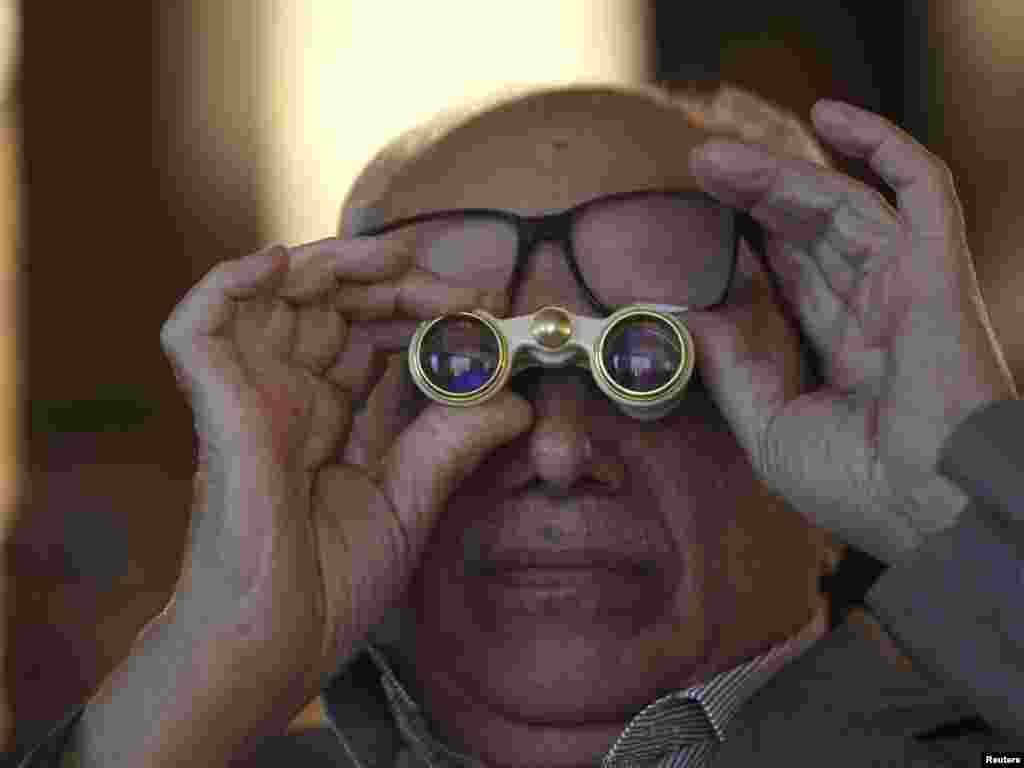 An investor uses binoculars to read stock updates at the Iraq Stock Exchange in Baghdad shortly after the election. - Photo by Mohammed Ameen for Reuters