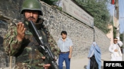 An Afghan police commando surveyed the scene after two Taliban militants were killed in a gun battle near the Afghan national peace jirga in Kabul.