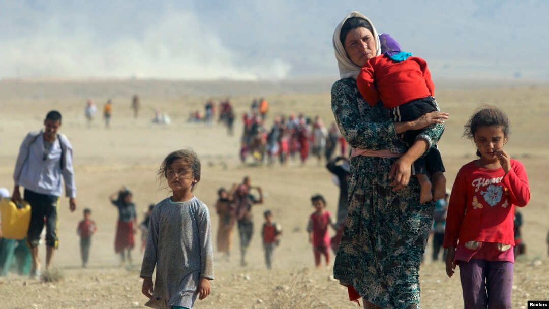Displaced people from the minority Yazidi sect, fleeing violence from forces loyal to the Islamic State in Sinjar town, walk toward the Syrian border, on the outskirts of Sinjar Mountain, earlier this week.