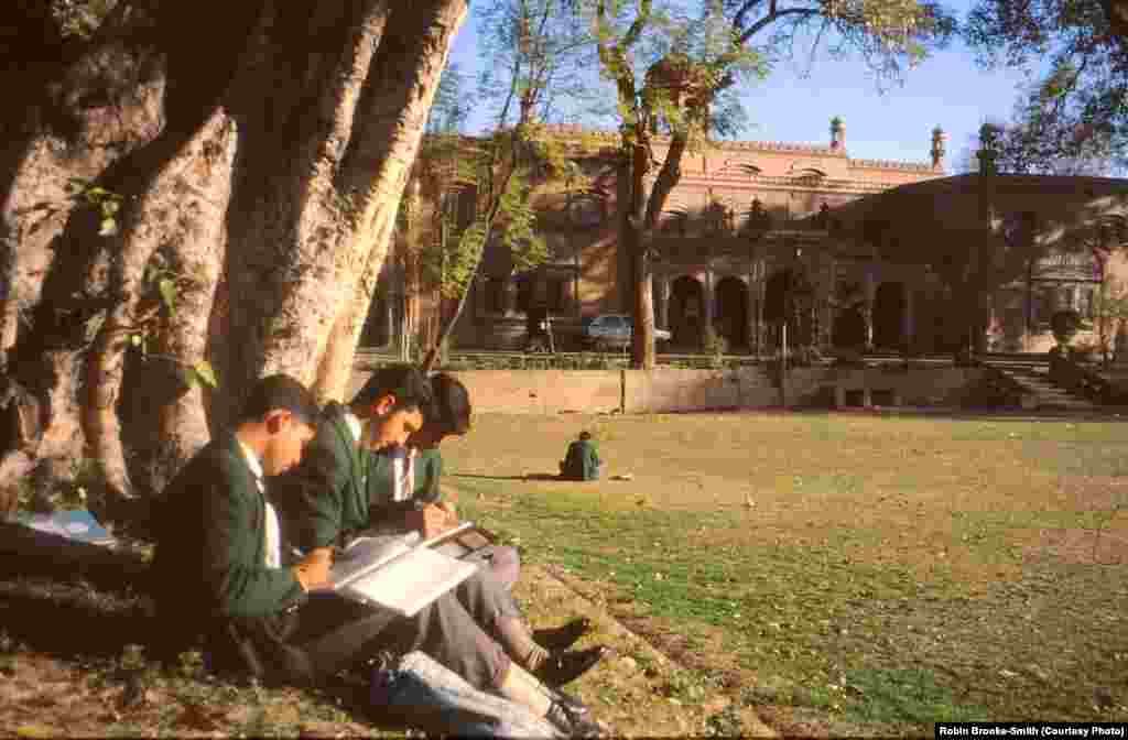 Students enjoying the winter sun by the tennis court. 