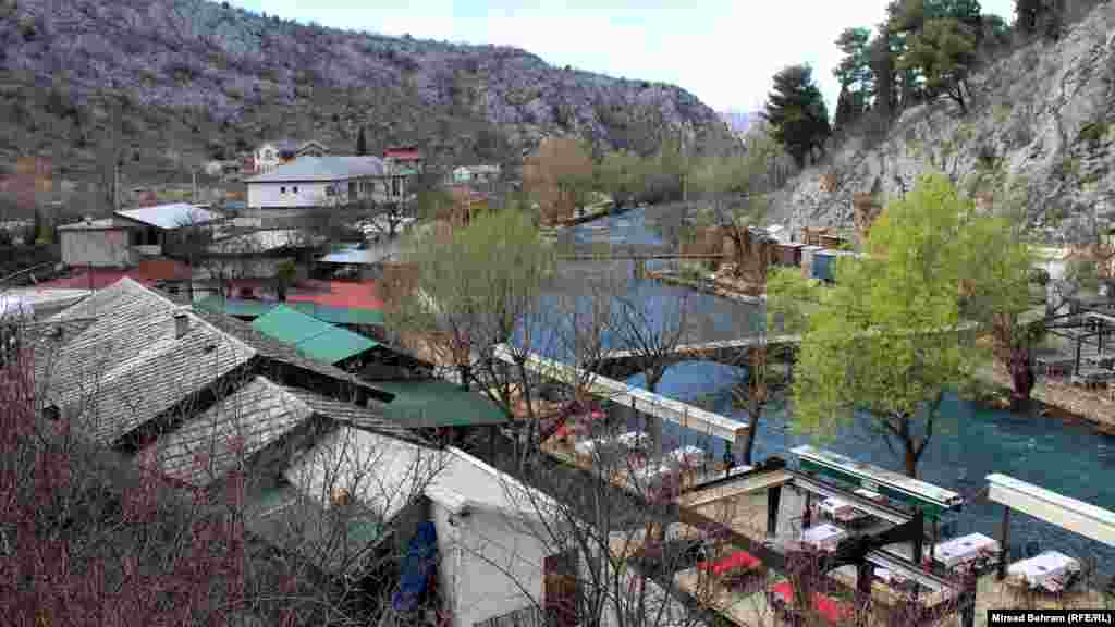 Pogled sa uzvisine na dio slikovitog mjesta Blagaj, oko 10 km južno od Mostara, nizvodno od izvora rijeke Bune. Na slici se vidi da su restorani na lijevoj obali rijeke Bune, kao i brojne suvenirnice s druge strane dva pješačka mosta, prazni, zbog pandemije virusa korona.