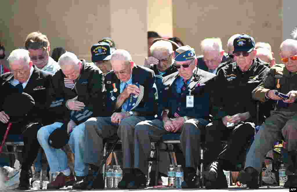 American veterans observe a minute of silence during a joint U.S.-French D-Day commemoration ceremony at the Normandy American Cemetery and Memorial in Colleville-sur-mer.