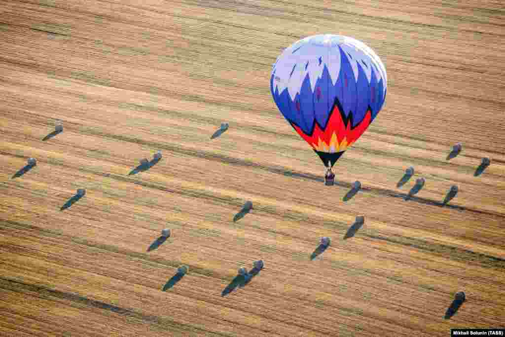 A hot-air balloon flies over a field during the Russian Volga Federal District hot-air balloon championships. (TASS/Mikhail Solunin)