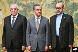 Ministrul chinez al Afacerilor Externe, Wang Yi (centru) alături de Mahmoud al-Aloul (s), vicepreședinte al Fatah și Mussa Abu Marzuk, un membru din conducerea Hamas, la întrevederea din 23 iulie, de la Beijing.