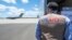 A USAID employee watches a U.S. Air Force plane preparing to deliver coronavirus aid to Russia last year.