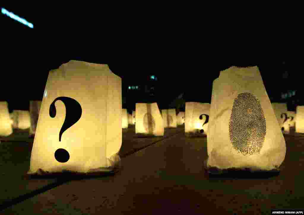 Lit candles are decorated with question marks and fingerprints as Kosovar Albanians remember Kosovo's missing persons in Pristina. (AFP/Armend Nimani)