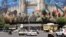 Vehicles travel past a huge banner in Tehran's Revolution Square as a cease-fire appeared to hold.