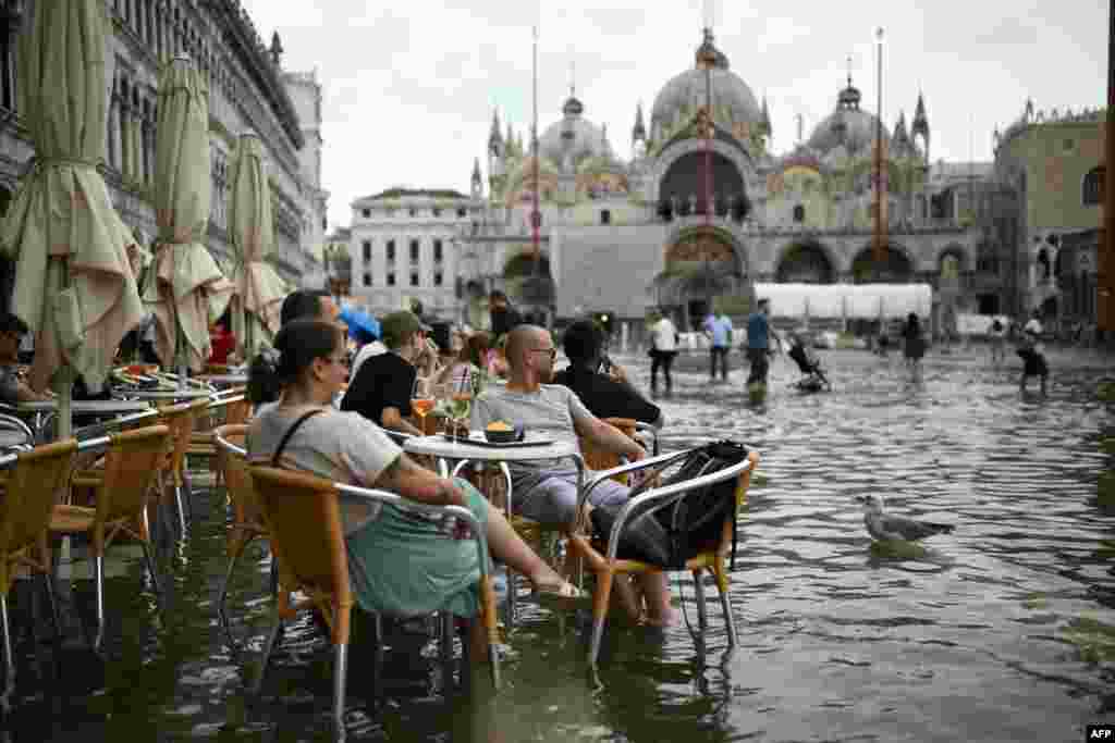 Odmaranje u ljetnoj bašti kafića na poplavljenom Trgu svetog Marka u Veneciji tokom plime, Italija, 5. septembra