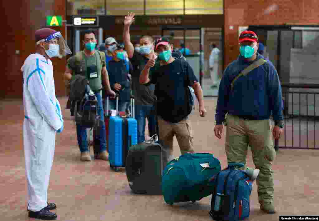 Nepalese men are relieved to land at Tribhuvan International Airport in Kathmandu, Nepal, on August 17 after being evacuated from Kabul.