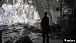 A Ukrainian police officer stands at the site of a Russian drone strike in Odesa on May 1.