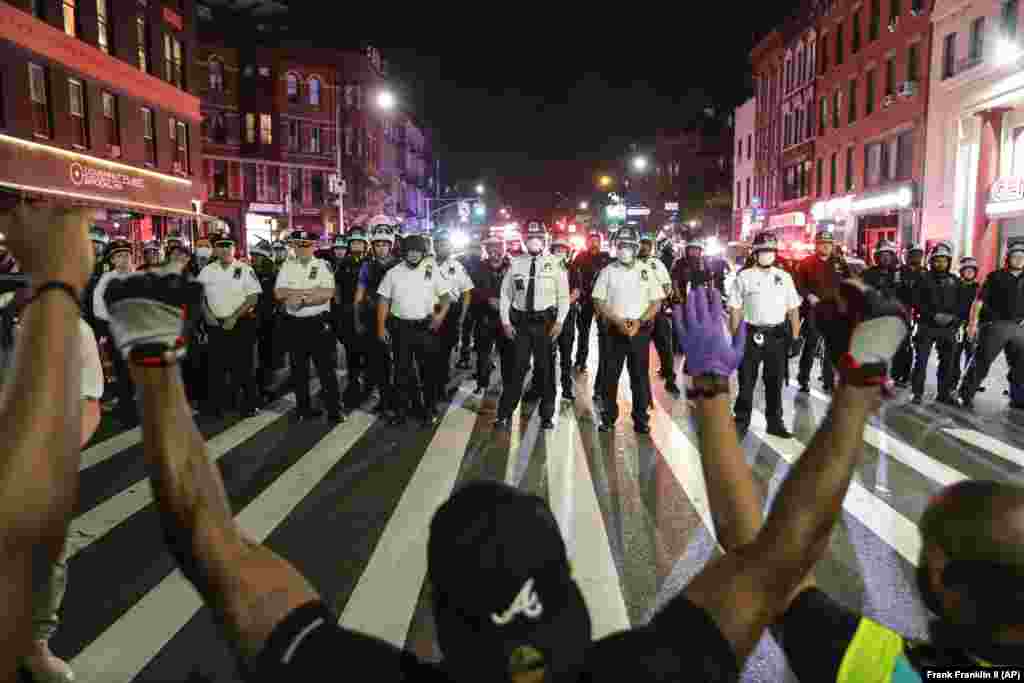 Протестувальники стоять на колінах на вулиці&nbsp;Flatbush Avenue перед поліцейськими Нью-Йорка під час акції пам&#39;яті за Джорджем Флойдом, який помер у Міннеаполісі внаслідок жорстоких дій поліцейського. Нью-Йорк, 4 червня 2020 року