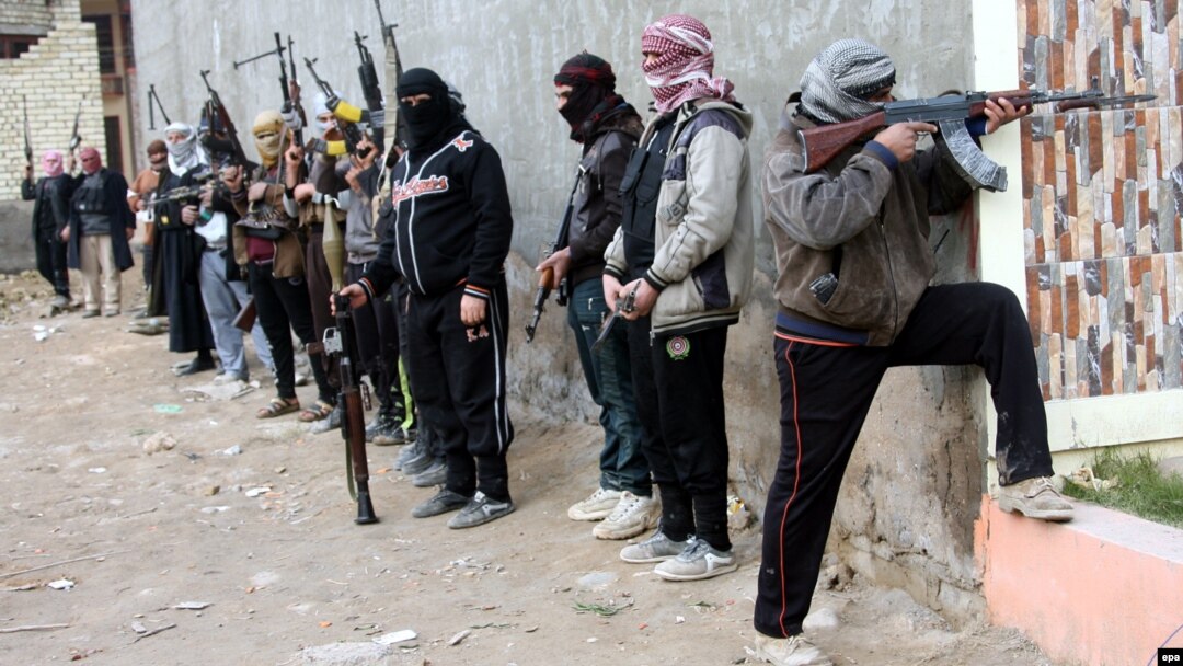 Sunni fighters carry RPG missile launcher and machine guns as they take up position in Fallujah city on January 5.