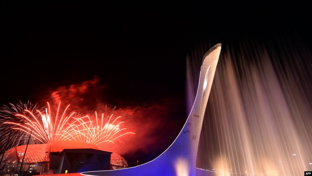 Russia -- Sochi - Fireworks explode behind the Olympic flame claudron after it was extinguished at the end of the Closing Ceremony of the Sochi Winter Olympics outside the Fisht Olympic Stadium on February 23, 2014. AFP PHOTO / YURI KADOBNOV