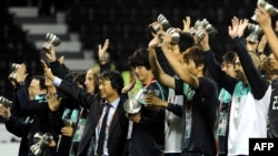 South Korean players and coach Cho Kwang-Rae (C) celebrate after beating Uzbekistan in their 2011 Asian Cup football match for third place at Al-Sadd Stadium in the Qatari capital Doha on January 28, 2011