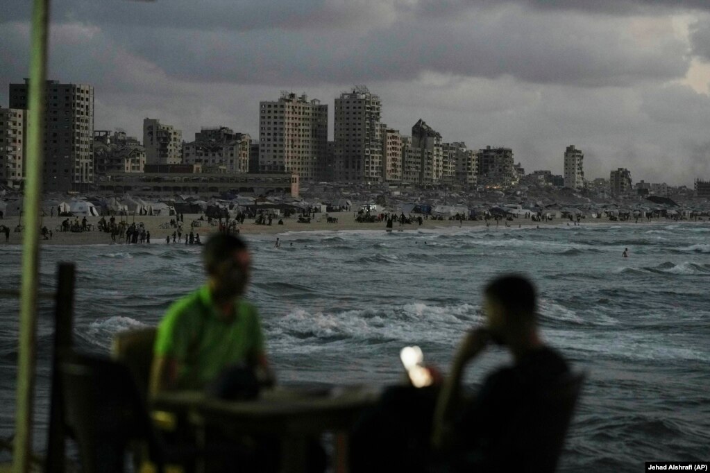Palestinezë duke kaluar kohën buzë detit, pranë një kampi në Qytetin e Gazës.