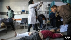 Palestinieni primind îngrijire de urgență la spitalul Kamal Edwan din Beit Lahia, în nordul Gazei, după ce soldații israelieni au tras în oamenii care așteptau ajutoare.