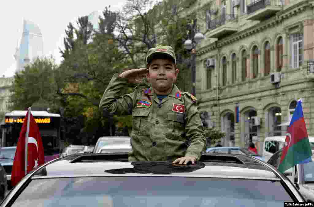 A boy wearing an Azerbaijani military uniform salutes during celebrations in the streets of the capital, Baku, on November 10 after Armenia and Azerbaijan agreed a cease-fire following a string of Azerbaijani victories in fighting over the breakaway Nagorno-Karabakh region. (AFP/Tofik Babayev)