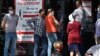 People wait outside a pharmacy in Almaty on July 8.