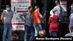 People wait outside a pharmacy in Almaty on July 8.