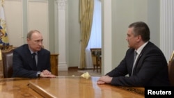 Russian President Vladimir Putin (left) meets with Crimean leader Sergei Aksyonov at the Novo-Ogaryovo state residence outside Moscow on April 14, where he named him acting governor.