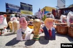 Фигурки, изображающие президента Мексики Клаудию Шейнбаум, президента США Дональда Трампа и кубок Чемпионата мира по футболу 2026 года. Мексиканский город Тихуана, вблизи границы с США. 30 мая 2026 года