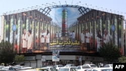 Pankarta në sheshin Enqelab që paraqet shkencëtarë bërthamorë dhe centrifuga me slogane “shkenca është fuqi” në gusht 2025.