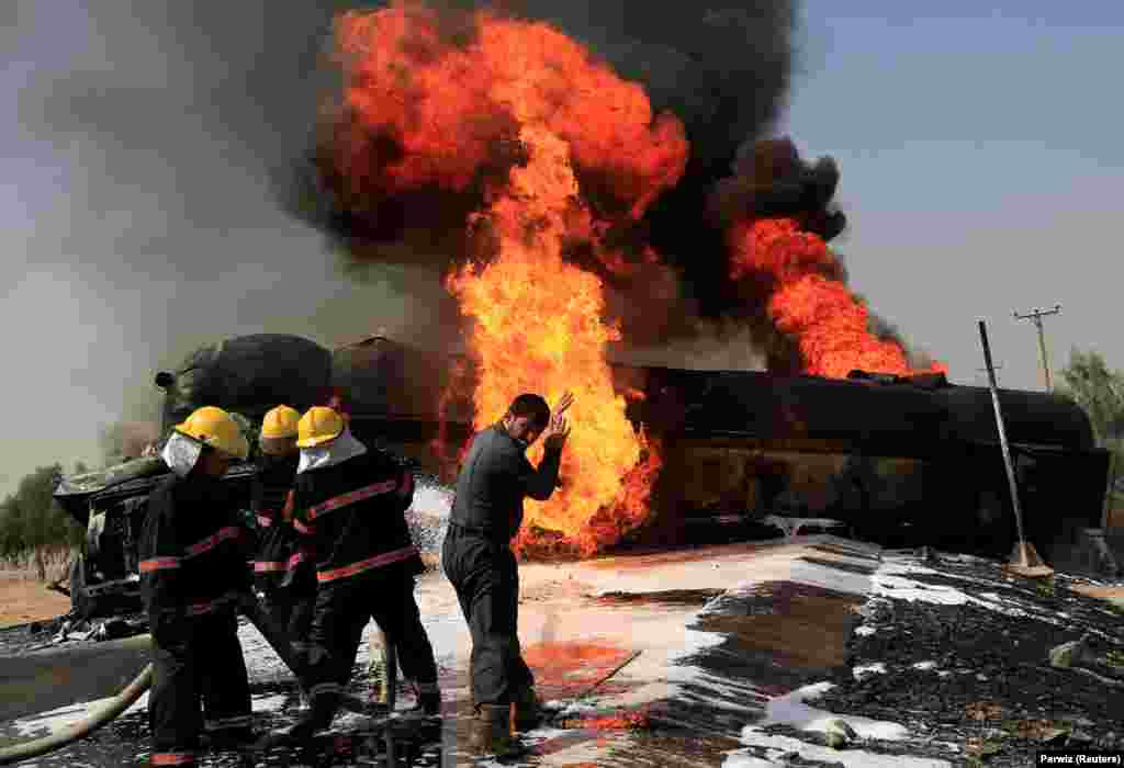 Afghan firefighters attempt to extinguish a burning fuel tanker that was hit by a magnetic bomb on the outskirts of Jalalabad on October 16. (Reuters/Parwiz)