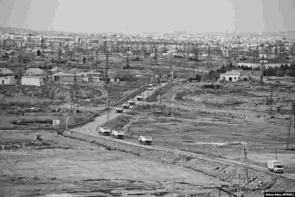 Neft buruqları arasından uzanan maşın yolu.