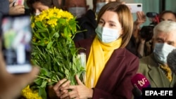 Кандидат в президенты от партии «Действие и солидарность» Майя Санду получает цветы после выступления о предварительных результатах второго тура президентских выборов в Кишиневе, 15 ноября 2020 года.
