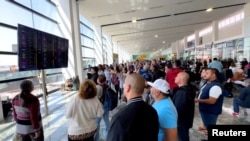Oamenii se adună la Aeroportul Internațional Guadalajara, unde mai multe zboruri au fost deviate sau anulate, în urma operațiunii militare împotriva cartelului de droguri.