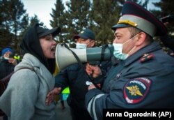 O femeie se ceartă cu un ofițer de poliție dotat cu portavoce, în timpul protestelor de susținere a opozantului Alexei Navalnîi - Ulan-Ude, capitala Buriației, 21 aprilie 2021