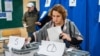 Romanian citizens vote at one of the three polling stations opened inside the "Spiru Haret" High School in Chisinau