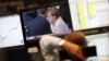 A trader at the Frankfurt stock exchange watches a news broadcast showing German Chancellor Angela Merkel. (file photo)